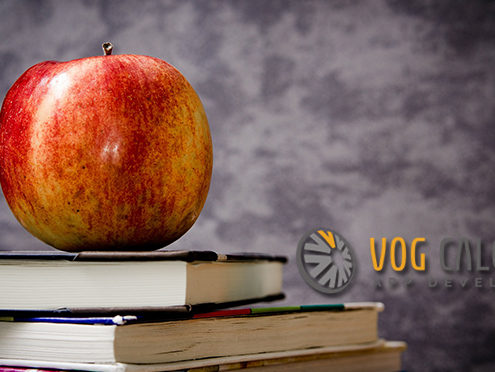 Banner image of an Apple, textbooks and a chalkboard background